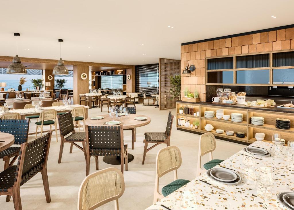 a restaurant with tables and chairs and a kitchen at INNSiDE by Meliá Alicante Porta Maris in Alicante