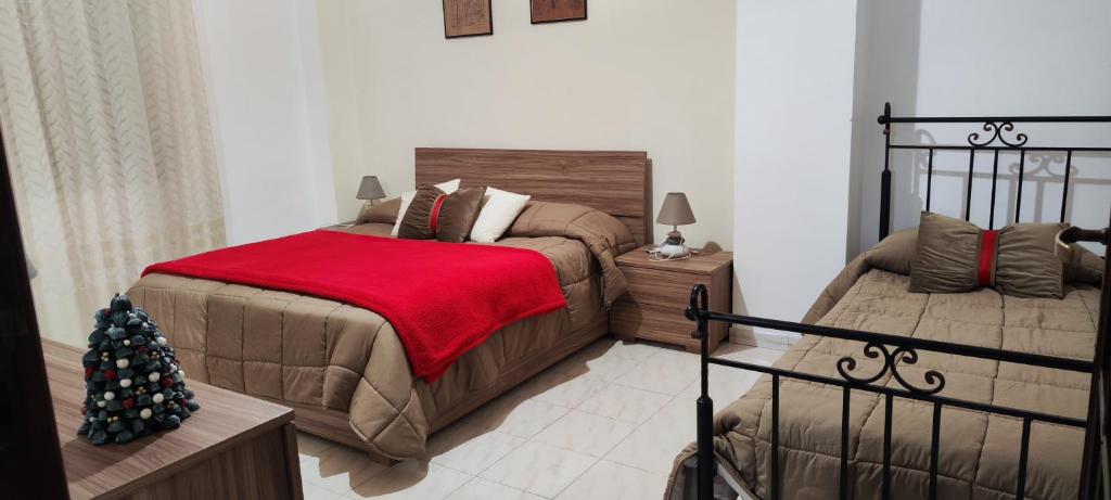ポンペイにあるDomus Parva, appartamento con giardinoのベッドルーム1室(ベッド2台、赤毛布付)
