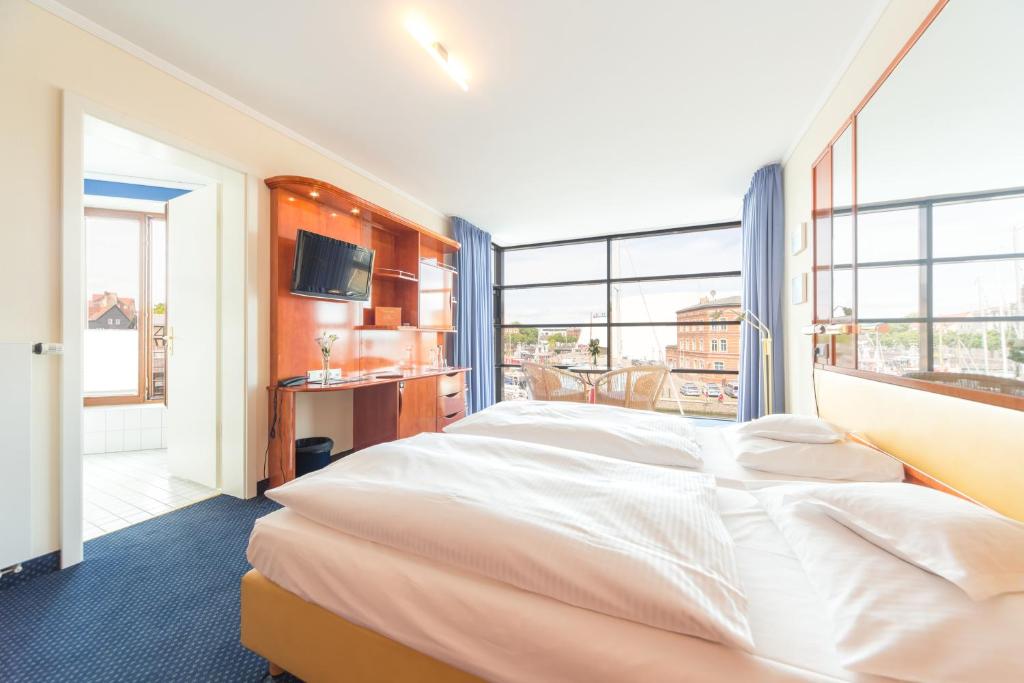 Postel nebo postele na pokoji v ubytování Hotel Kontorhaus Stralsund
