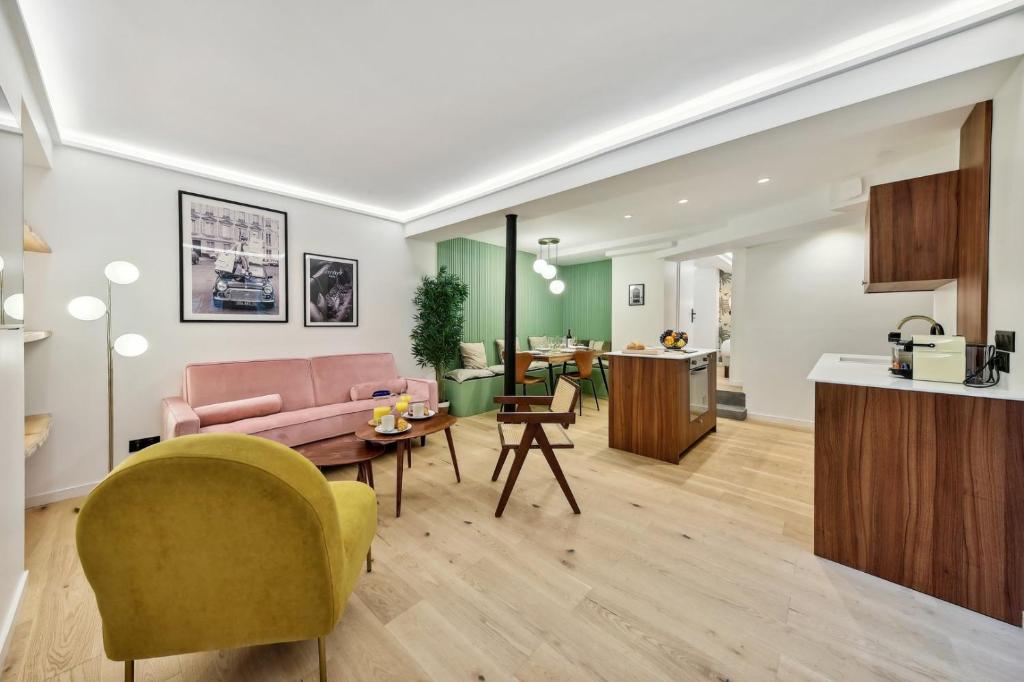 un salon avec un canapé rose et une table dans l'établissement 506 Suite Cadet - Superb apartment in Paris, à Paris