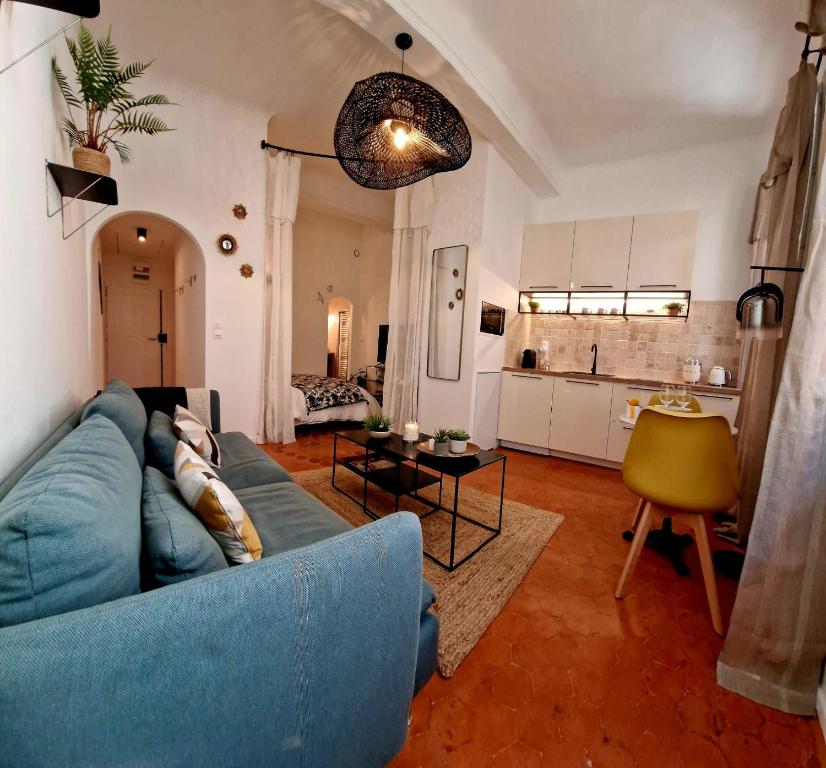 un salon avec un canapé bleu et une cuisine dans l'établissement Appartement Cosy Hyper Centre Climatisé - Rue Bédarrides, à Aix-en-Provence