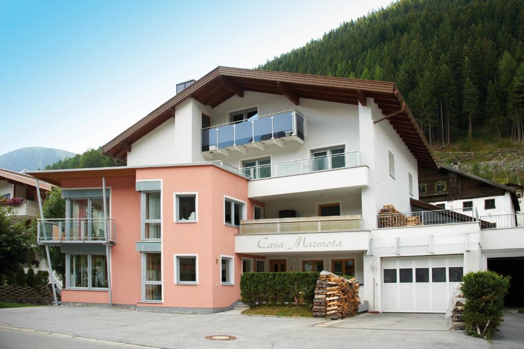 a large building with a mountain in the background at Casa Marmota in Ischgl