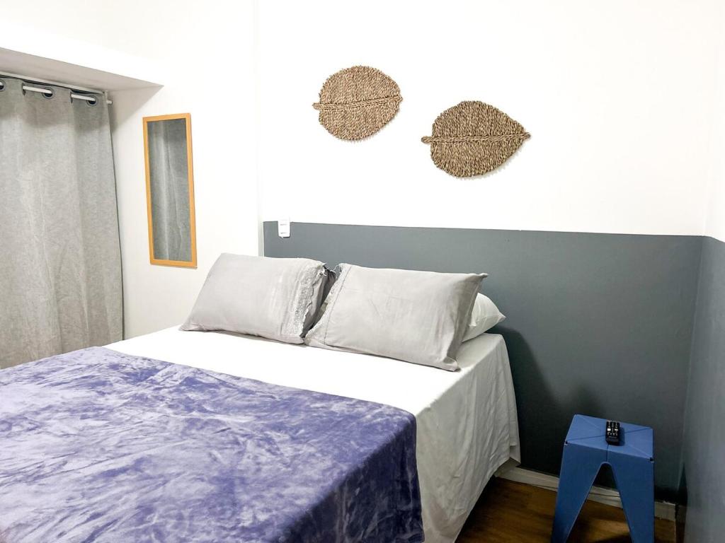 a bedroom with a bed with a blue stool at I-17 um Studio aconchegante in Maceió