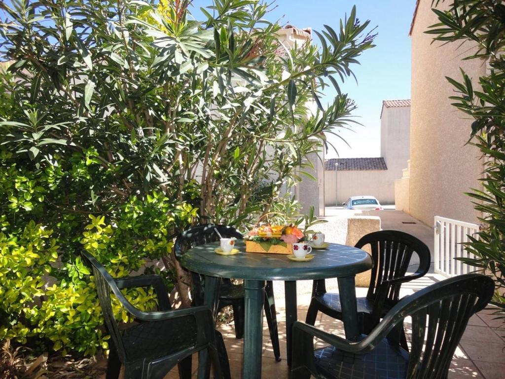 une table et des chaises bleues sur une terrasse dans l'établissement SP480-165 Maison 2 pièces mezzanine SAINT PIERRE LA MER, à Saint Pierre La Mer