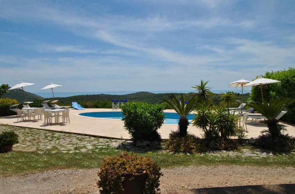 a pool with tables and chairs and umbrellas at Villa Saha splendida dimora immersa tra gli ulivi in Itri