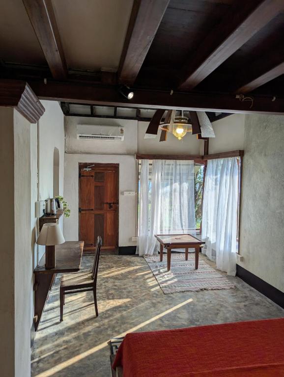 a living room with a table and a chair at Svarna in Udupi