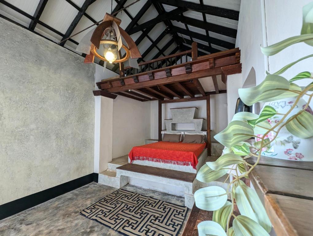 a room with a red bed and a ceiling at Svarna in Udupi