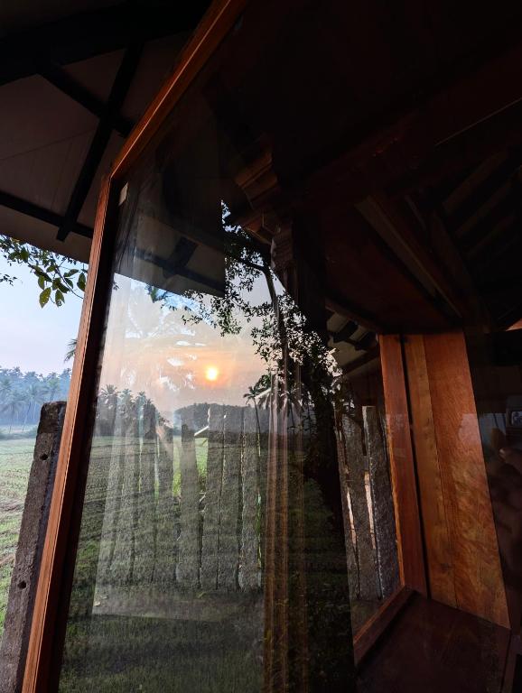 a window of a house with a view of a field at Svarna in Udupi