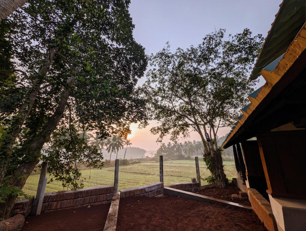 a view of a field from a house with trees at Svarna in Udupi