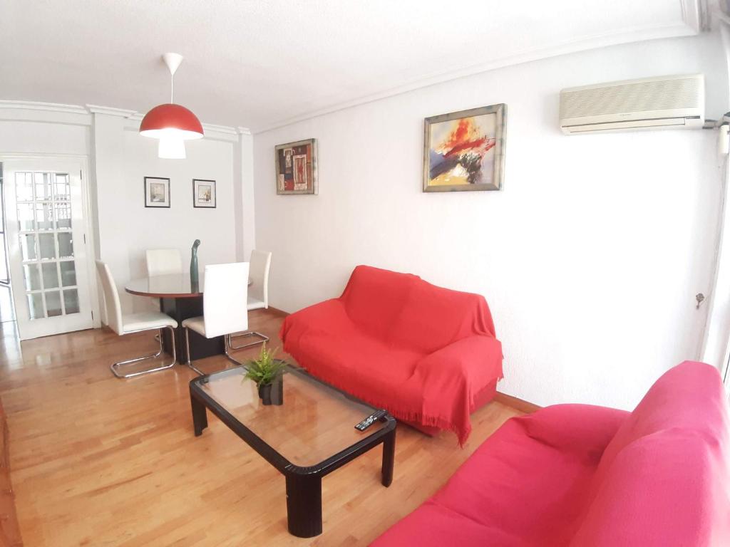 a living room with a red couch and a table at Apartamento Cerca Estacion de Bus in Murcia