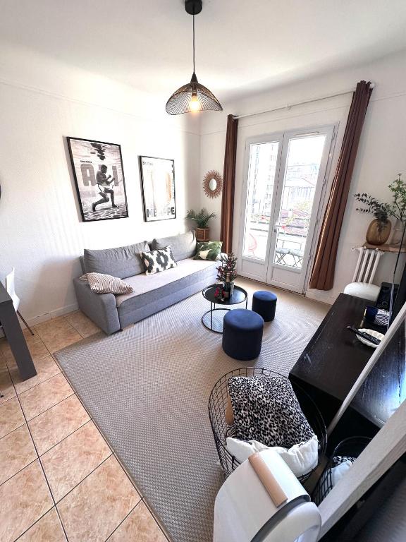 un salon avec un canapé et une table dans l'établissement Appartement avec balcon, 5 min du Métro 1-6, Nation, Disneyland, Zoo, Bois de Vincennes, à Paris