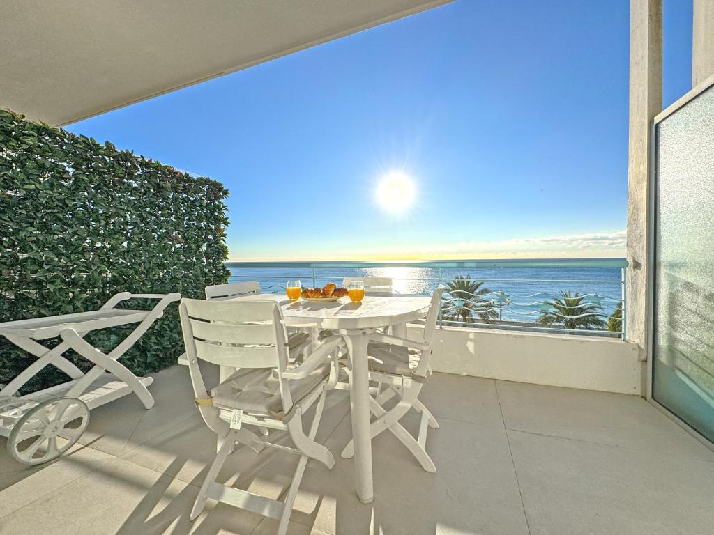 a table and chairs on a balcony with a view of the ocean at Sea Front Condo Promenade in Nice