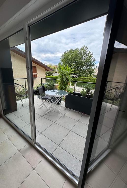 - une vue sur le patio depuis une fenêtre avec une table dans l'établissement Bel appartement proche du lac, à Duingt