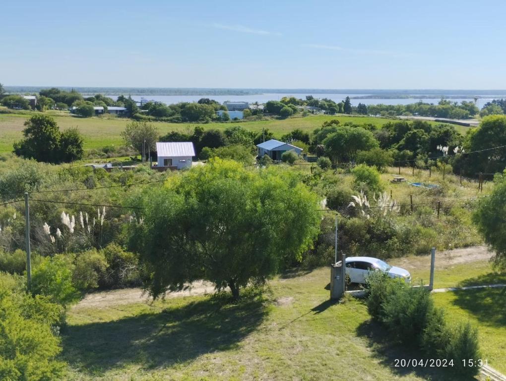 a view of a farm with a car parked in a field at CASA QUINTA CON ESPECTACULAR VISTA Al RÍO in General Alvear