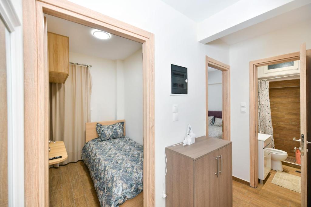 Ruby's Apartments Platamonas في بلاتامون: غرفة نوم صغيرة بها سرير وحمام