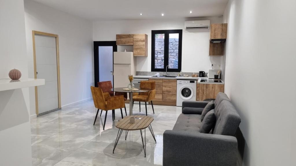 un salon et une cuisine avec un canapé et une table dans l'établissement Les Logis du Sud - Pampa et Olivier, à Gallargues-le-Montueux