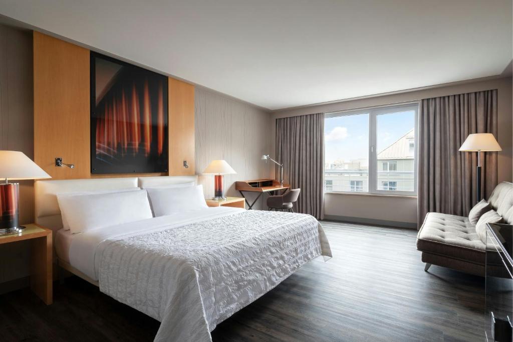 a hotel room with a bed and a couch at Le Méridien Munich in Munich