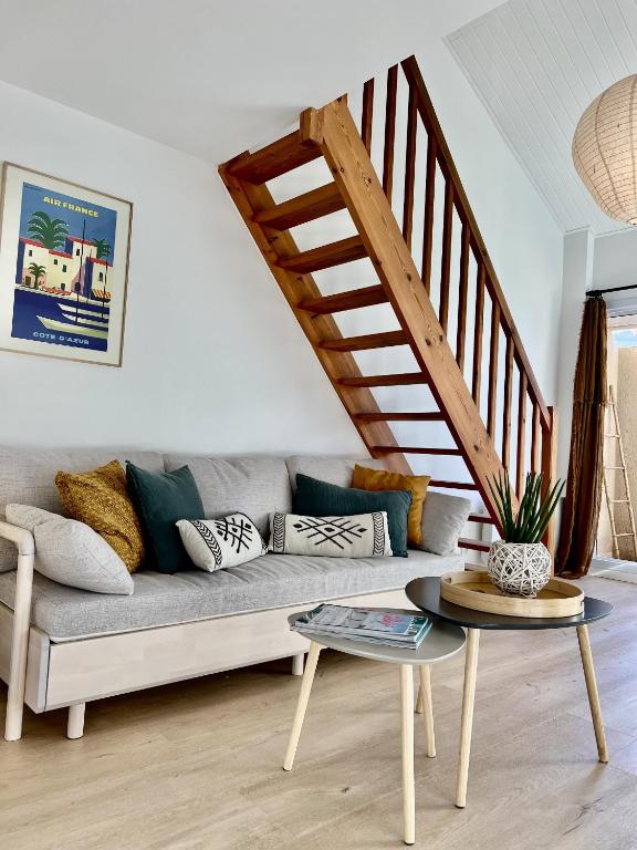 un salon avec un canapé et un escalier dans l'établissement Duplex aperçu mer chaleureux 3 personnes, à Les Sables-dʼOlonne