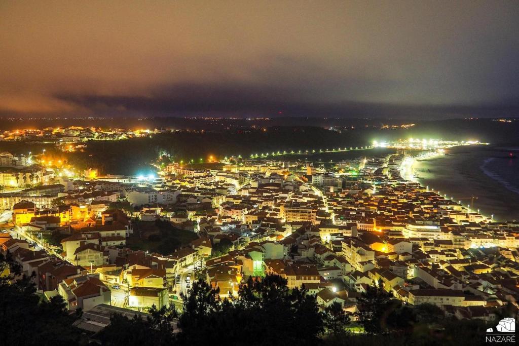a view of a city at night with lights at Hotel Mare in Nazaré