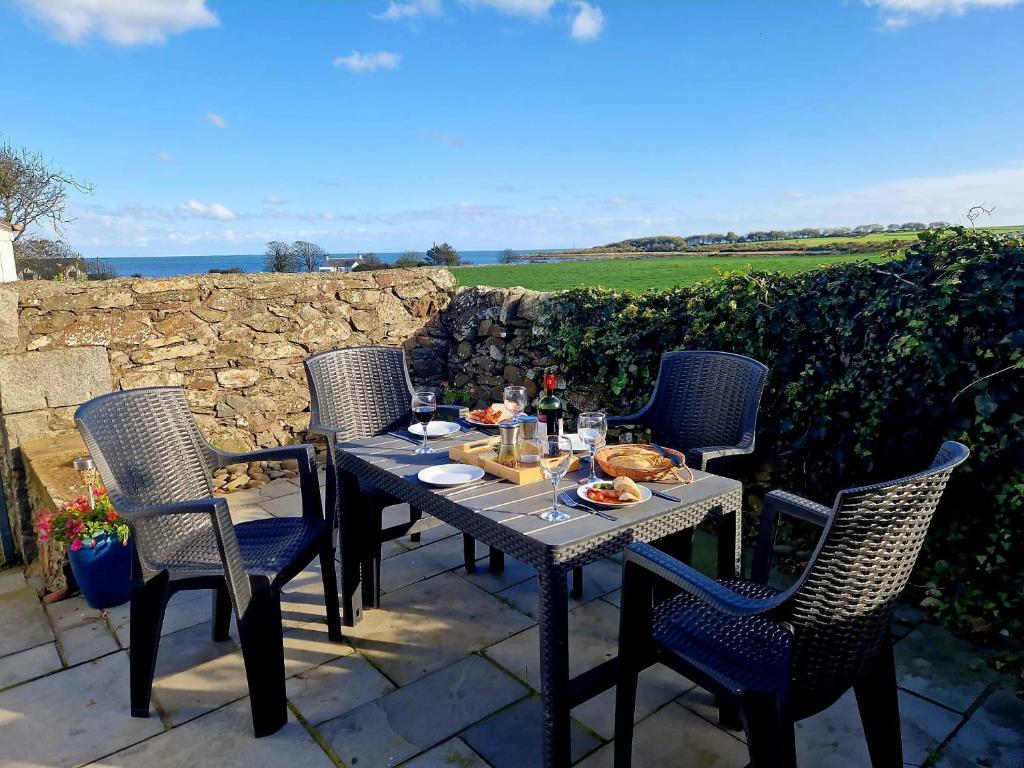 un tavolo e delle sedie seduti su un patio di Mulberry Cottage a Whithorn