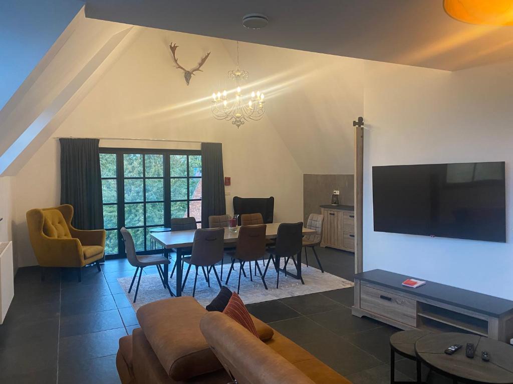 Una sala de estar con un sofá y una mesa con sillas. en La Forteresse, en Borgloon