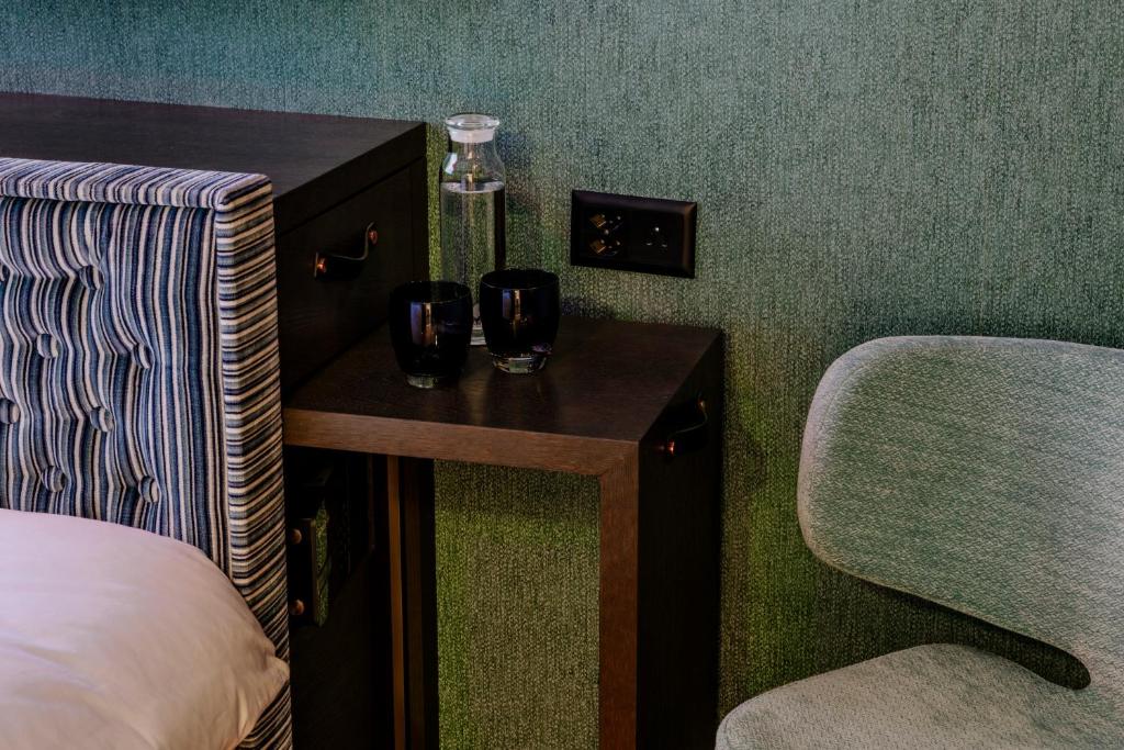 a room with two glasses on a table and a chair at Opera Hotel Zürich in Zürich