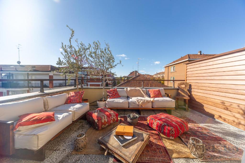 un patio con sofás y una mesa en el balcón en Casa Madera with lovely terrace, en Milán