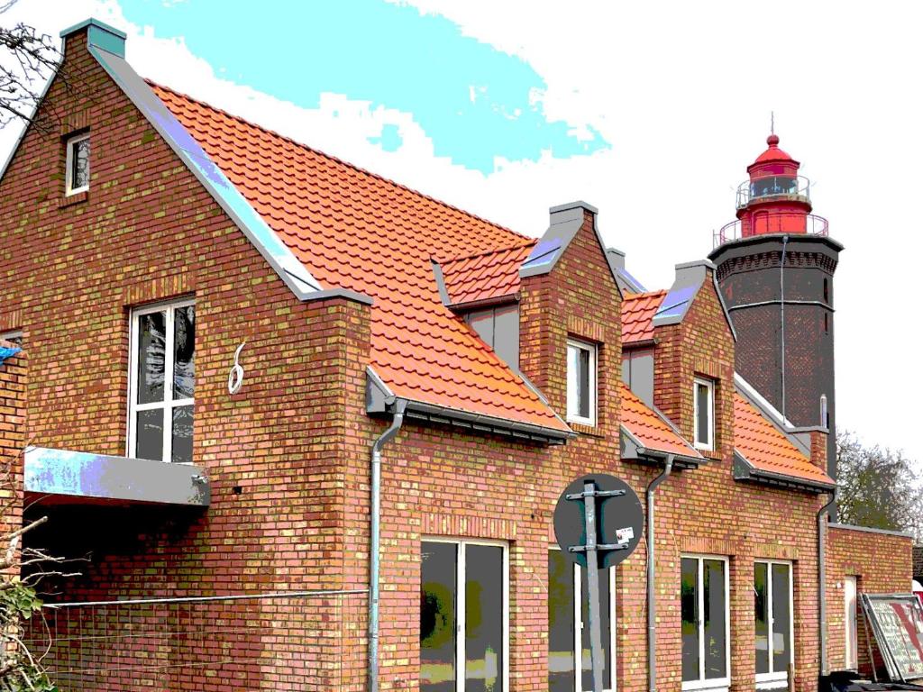 un edificio de ladrillo con un faro en el fondo en Am Dahmer Leuchtturm 23c, en Dahme