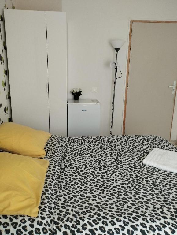 - une chambre avec un lit aux motifs noir et blanc dans l'établissement 2 Chambres Communicantes JM 4 Bonneuil, à Bonneuil-sur-Marne
