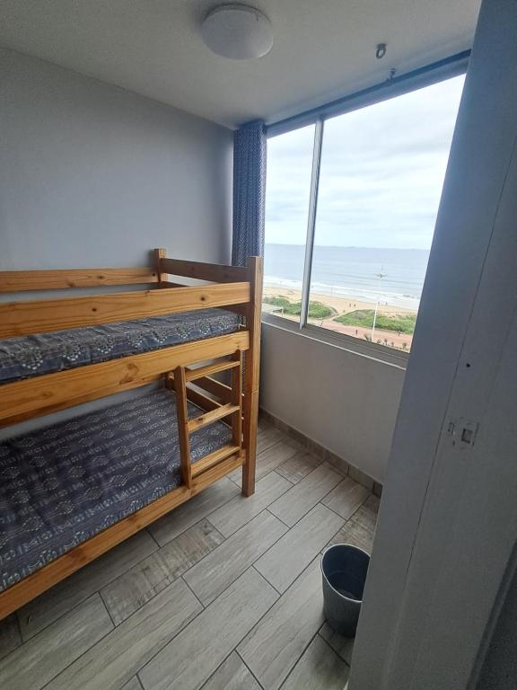 a room with two bunk beds and a large window at Shaka Shores in Durban