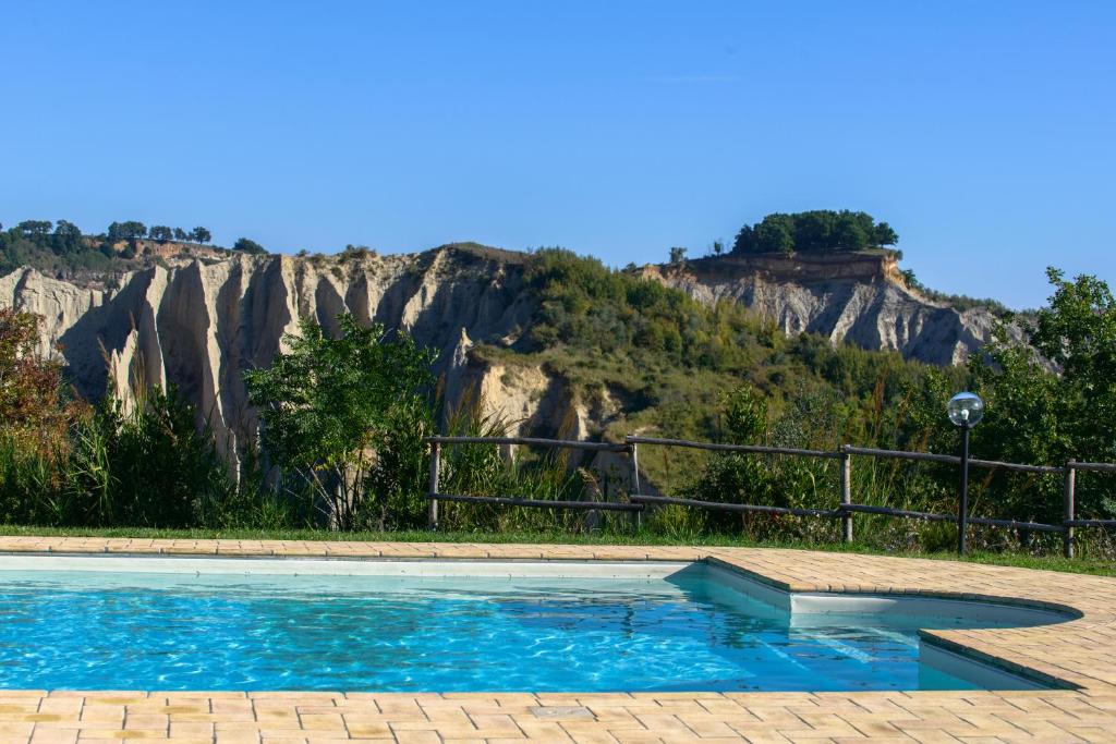 een zwembad met een berg op de achtergrond bij Villa I Calanchi Di Civita in Bagnoregio