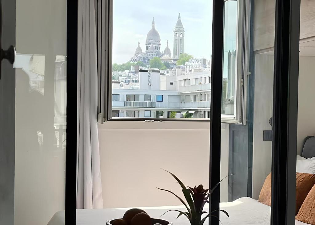 Cette chambre dispose d'une fenêtre offrant une vue sur la ville. dans l'établissement Superbe Loft avec Vue Incroyable sur Montmartre, à Paris