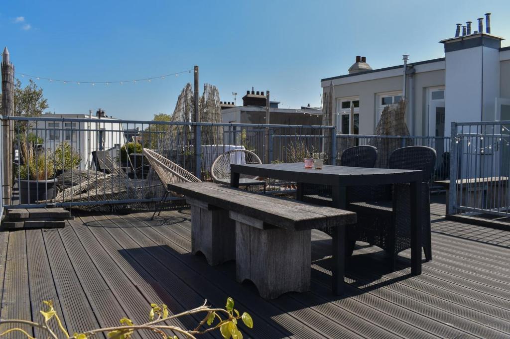 a bench and a table on a deck at NEW Roof terrace apartment in Jordaan Area in Amsterdam