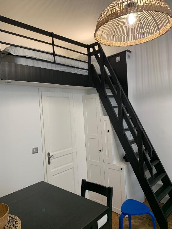 Cette chambre comprend des lits superposés, une table et une lampe. dans l'établissement Studio cœur de ville, au Mans