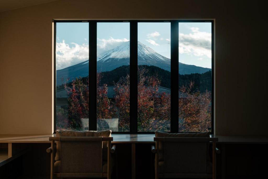a view of a mountain through a large window at 富士山望むプライベートヴィラ 900平方メートルの敷地を貸切利用 憩 ikoi Fuji サウナ 4Kシアター in Fujikawaguchiko
