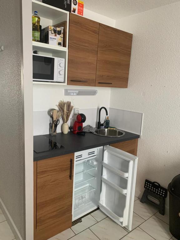 une petite cuisine avec un évier et un réfrigérateur dans l'établissement Studio Club Engaly II - Valentine, à Aragnouet