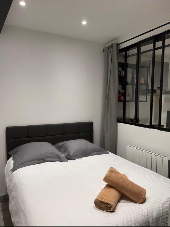 une chambre avec un lit avec une serviette dessus dans l'établissement L'Herbe ou ville, à Lyon
