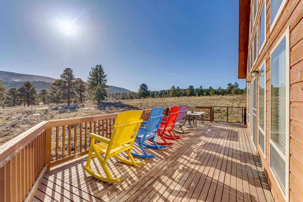 una fila di sedie colorate sedute su un ponte di Mountain Home with Deck 1 Mi to Angel Fire Resort! ad Angel Fire