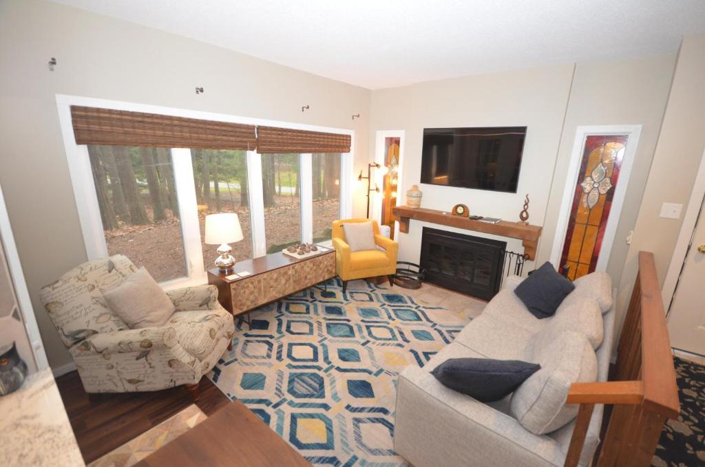 un salon avec deux chaises et une cheminée dans l'établissement South Village 7, à Glen Arbor