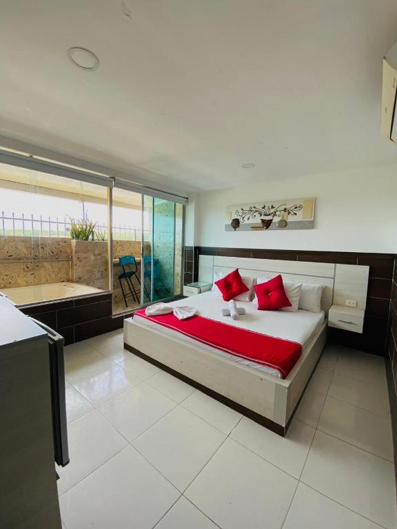 a large bedroom with a large bed with red pillows at Hotel Suite Royal in Melgar