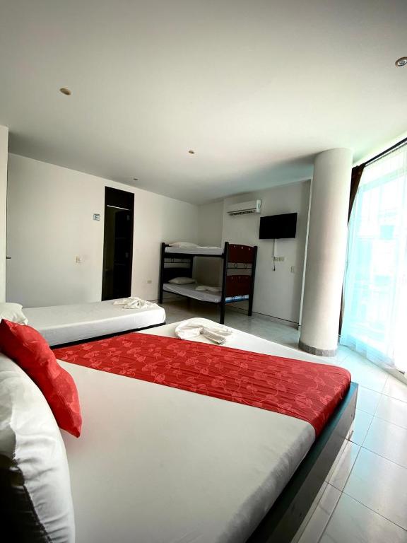 a bedroom with two beds and a living room at Hotel Suite Royal in Melgar
