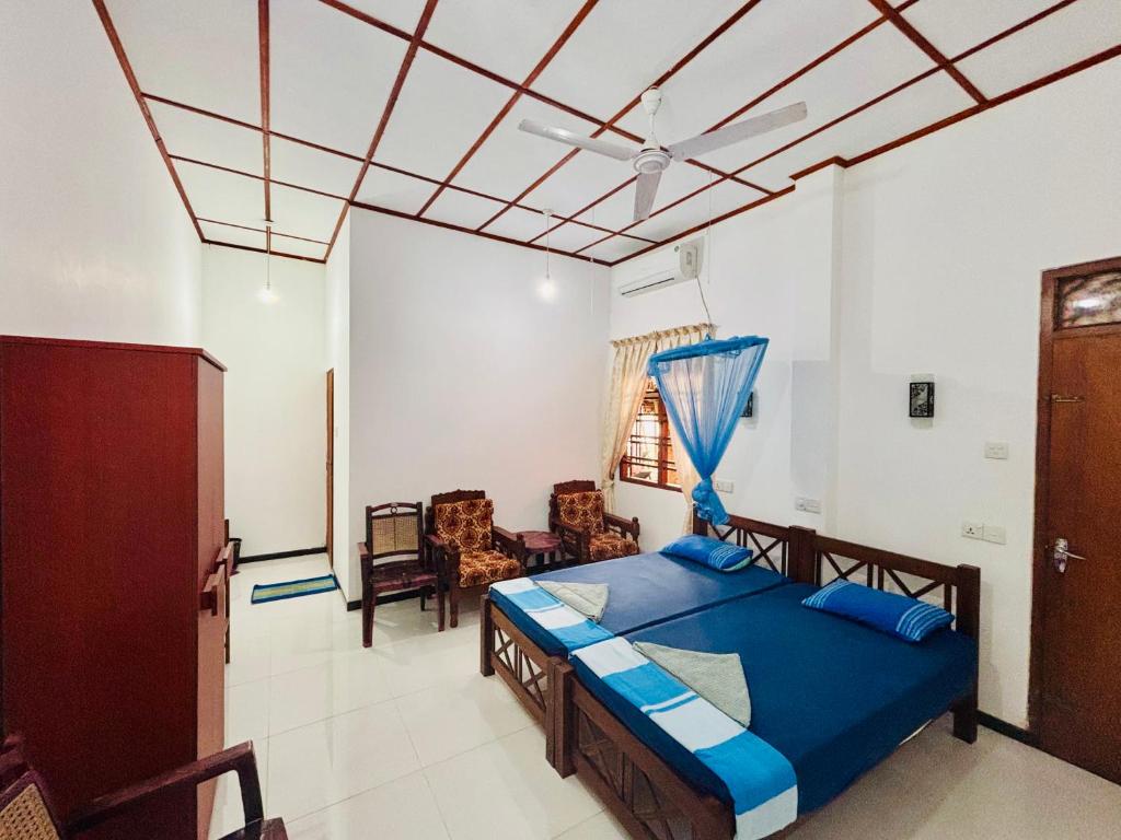 ヒッカドゥワにあるGolden Beach Guest House and Restaurantの青い掛け布団が敷かれたベッドのある寝室
