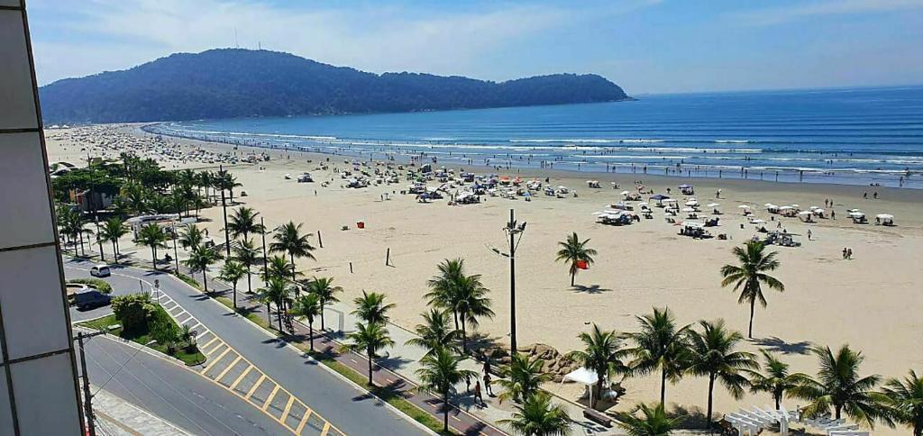a beach with a lot of people and the ocean at Kitnet frente praia Boqueirao in Praia Grande