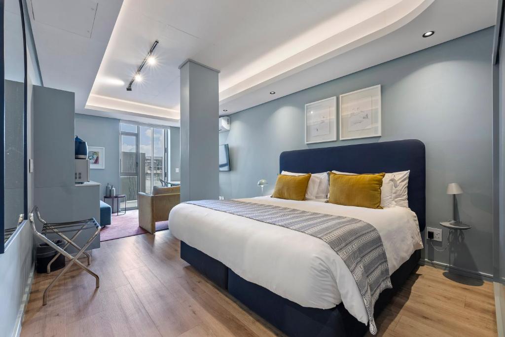 a bedroom with a large bed with a blue wall at Quarters 405 in Cape Town