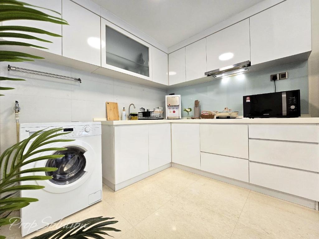 a white kitchen with a washing machine in it at Loft Suite Central City 2BR JB CIQ 7Pax in Johor Bahru