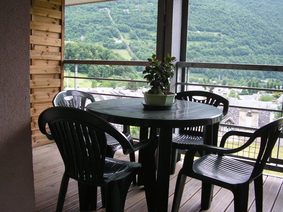 a table with chairs and a potted plant on a balcony at T2 Cabine calme vu montagne in Luz-Saint-Sauveur