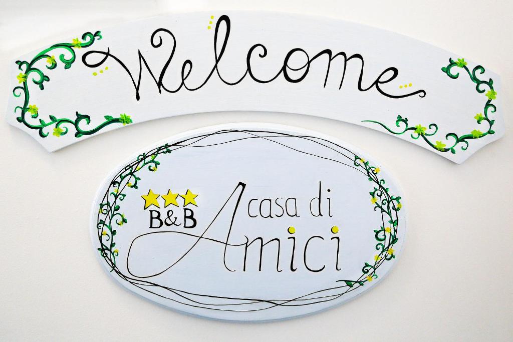 una placa con una señal que diga bienvenida bc aoscana d mimic en B&B A casa di amici, en Giardini Naxos