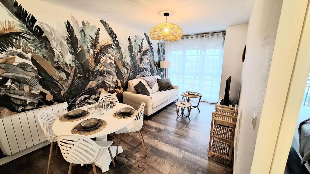un salon avec une table et un canapé dans l'établissement Appartement cosy, balcon et place privée, au Mans