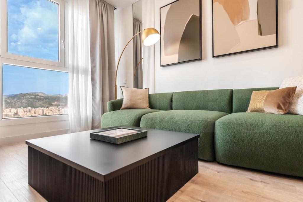 a living room with a green couch and a coffee table at Panoramic skyrise on the 20th floor by REMS in Málaga
