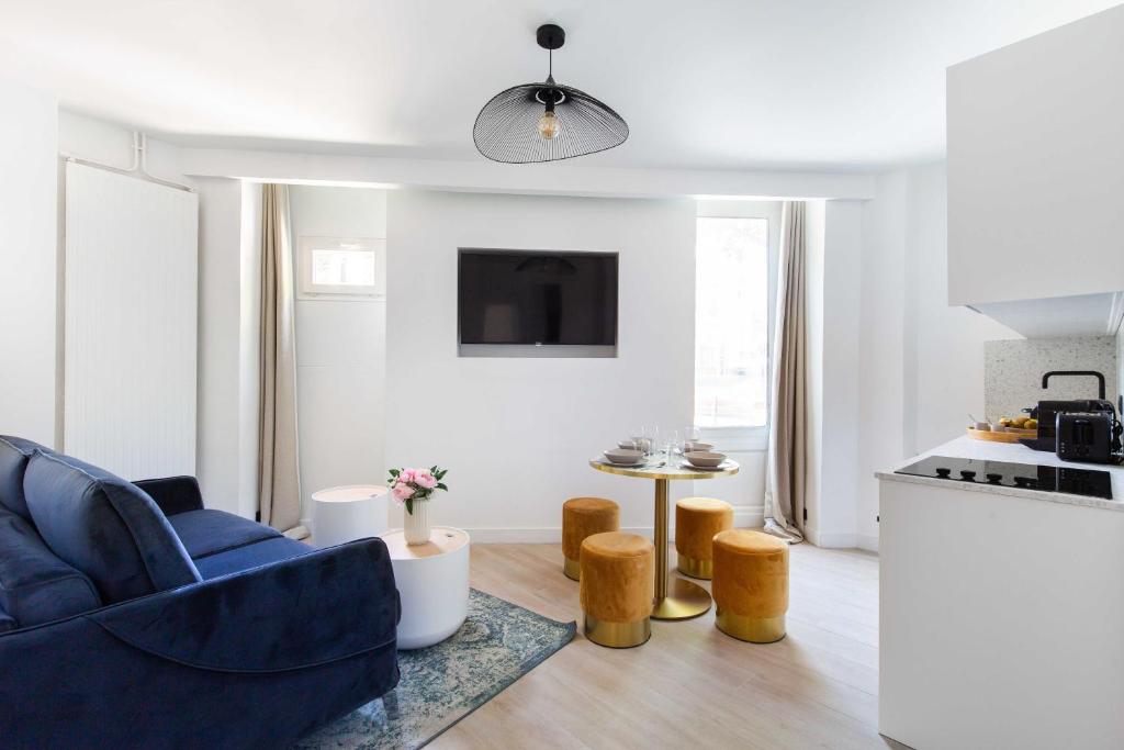 un salon avec une chaise bleue et une cuisine dans l'établissement Cosy Apartment - Parc des expositions Tour Eiffel 2, à Paris